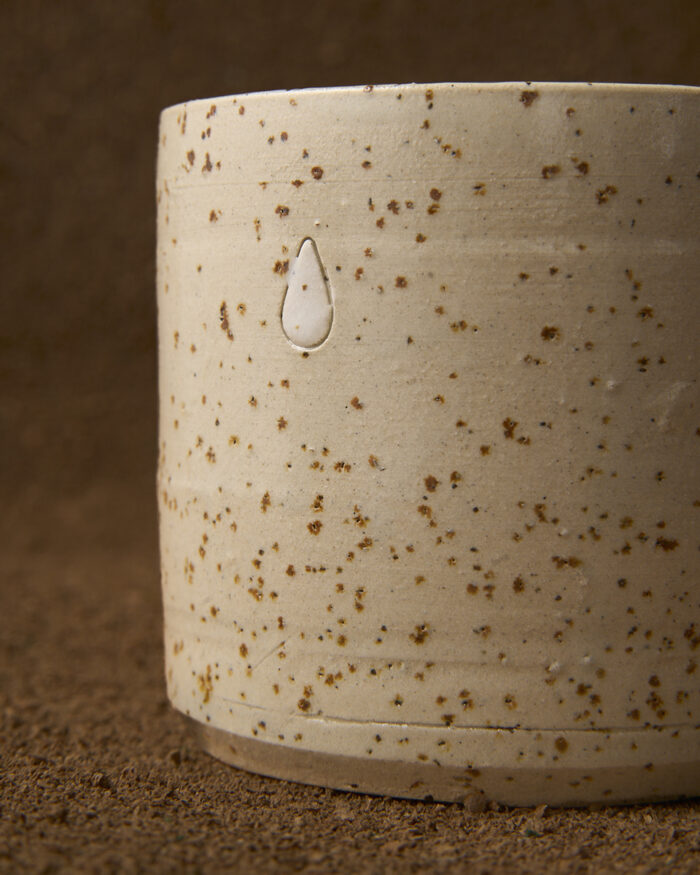 Cunca con asa en gres moteado claro da coleccion Pingas. Debuxos de gotas con engobe e esmaltada en transparente azulado.