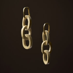 Pendentes Elos en gres crema mate con peche en ouro sobre fondo escuro