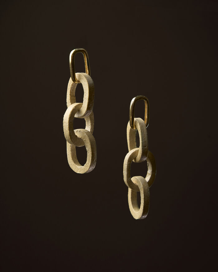 Pendentes Elos en gres crema mate con peche en ouro sobre fondo escuro